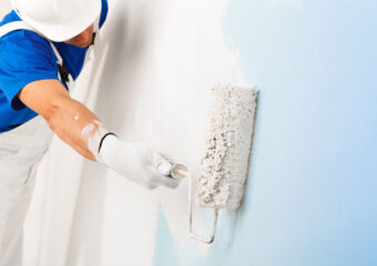 painter painting a wall with paint roller