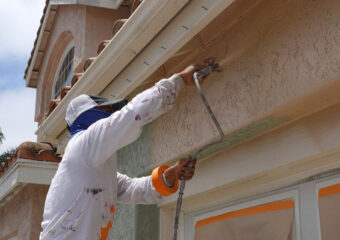 Professional contractor using a spray paint gun to paint the stu